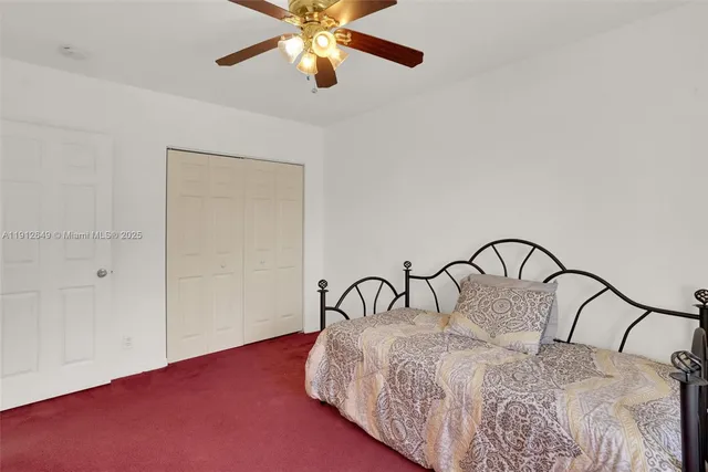 an empty room with a window and a ceiling fan