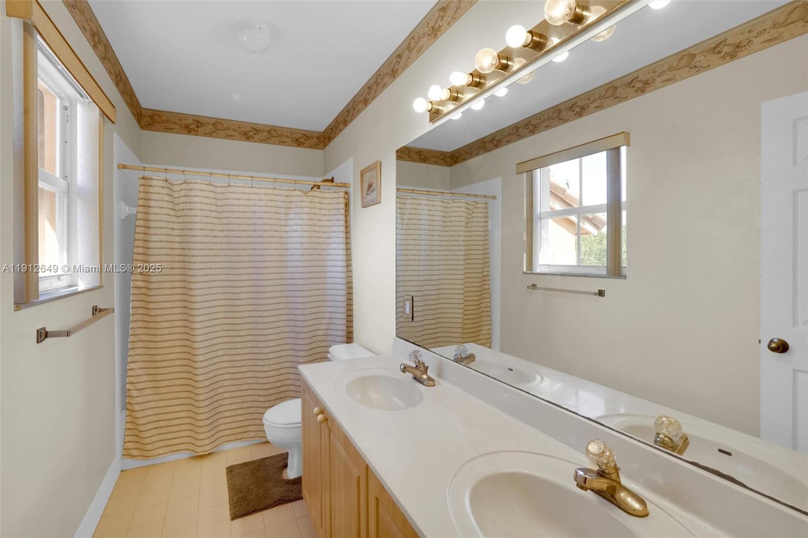 13117 Southwest 49th Court Miramar, FL 33027 - Photo 44 of 65 a bathroom with a sink a toilet a mirror and shower