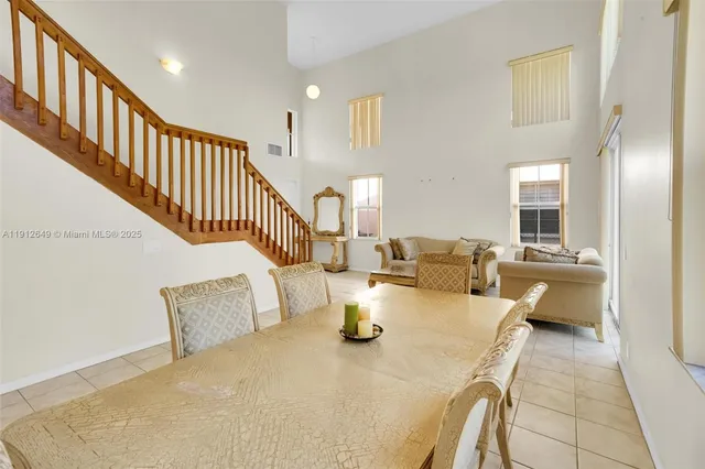 a living room with couches and kitchen view with wooden floor