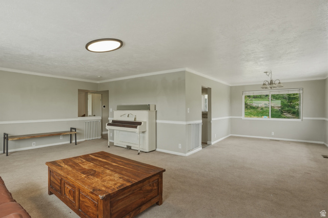 500 North 800 East Springville, UT 84663 - Photo 7 of 51 Living room with hanging lights, light colored carpet, ornamental molding, and a textured ceiling
