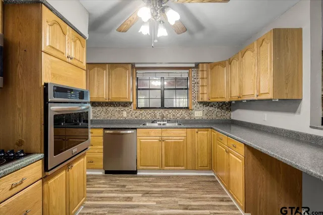 a kitchen with stainless steel appliances granite countertop a sink stove and cabinets