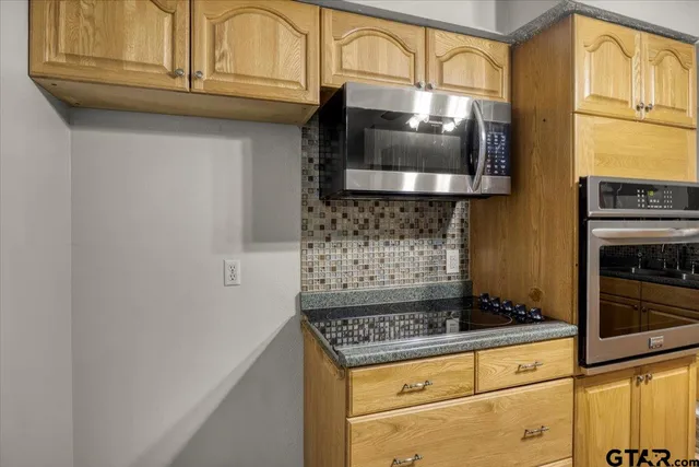 a kitchen with stainless steel appliances granite countertop a stove and a microwave