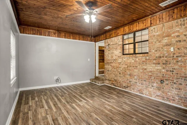 a view of a room with wooden floor and brick walls