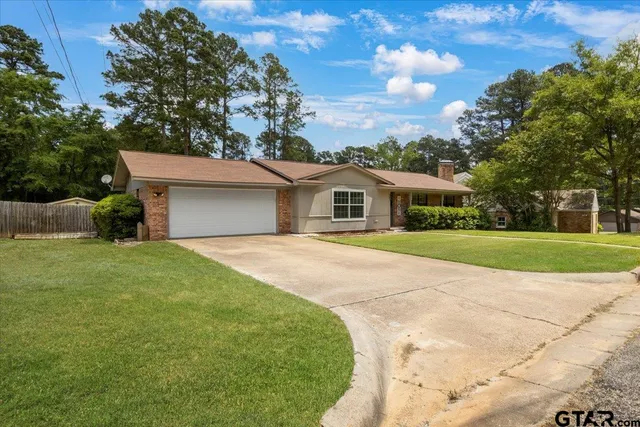 a front view of a house with yard and green space