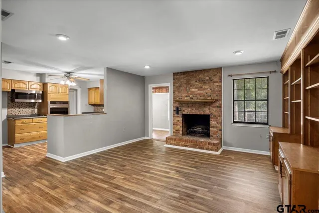 a view of a big room with wooden floor and a kitchen
