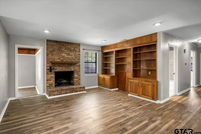 a view of an empty room with a fireplace and a window