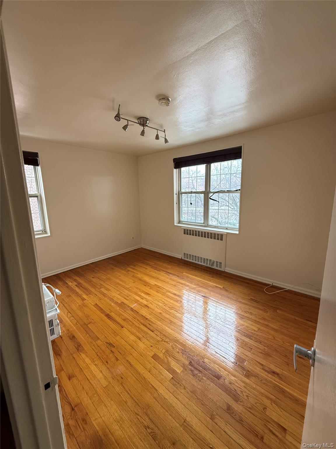 770 Bronx River Road, Unit A41 Yonkers, NY 10708 - Photo 5 of 10 an empty room with wooden floor and windows
