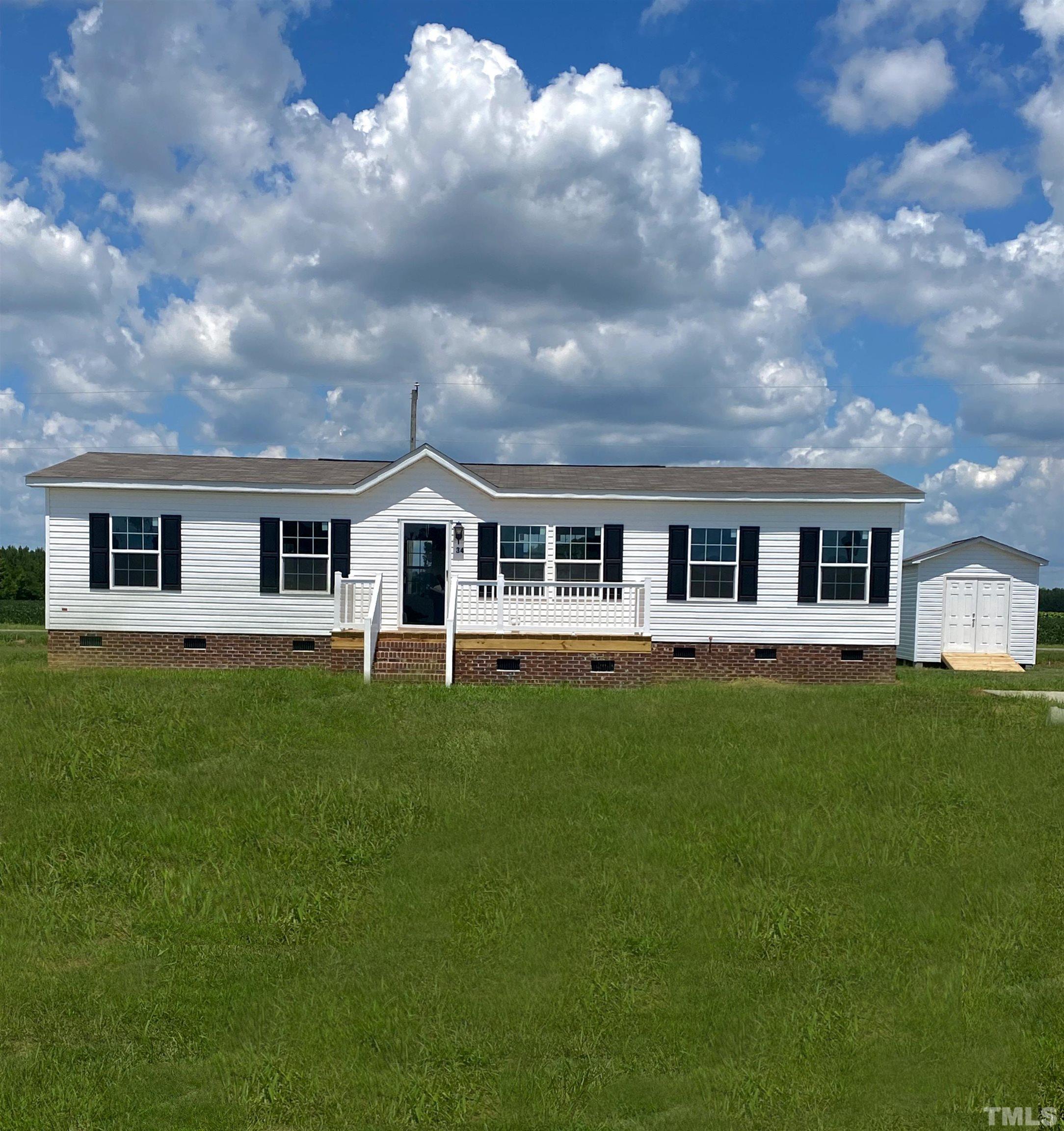 34 Ruddy Duck Lane Pine Level, NC 27576 - Photo 1 of 17 a front view of a house with a garden