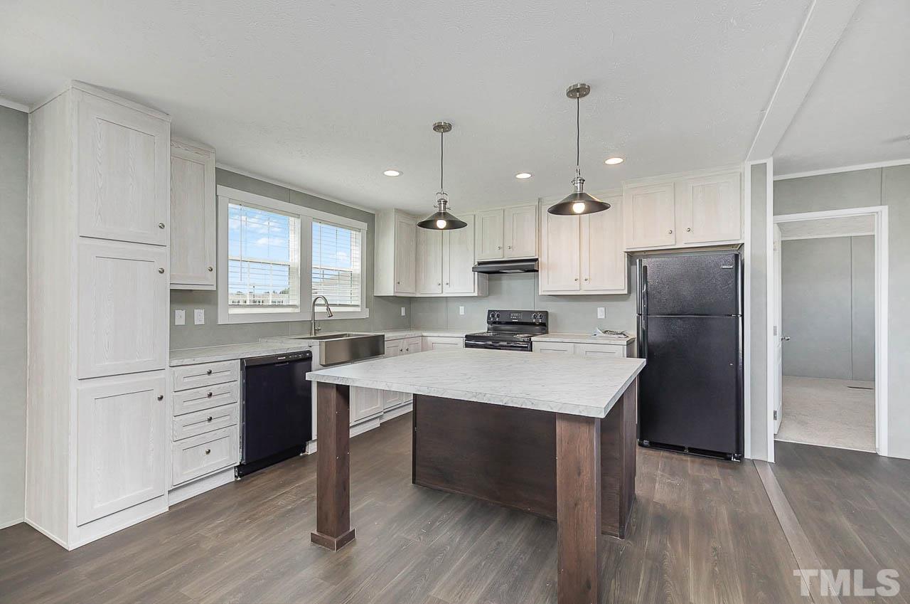 34 Ruddy Duck Lane Pine Level, NC 27576 - Photo 4 of 17 a kitchen with a refrigerator a sink dishwasher a stove and white cabinets with wooden floor