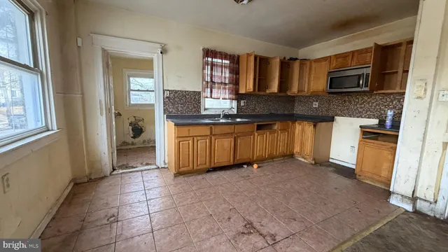 a large kitchen with granite countertop a stove a sink and a microwave