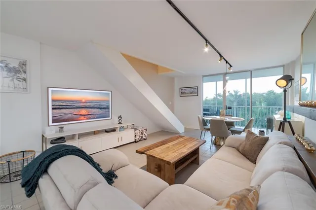 a living room with furniture and a floor to ceiling window