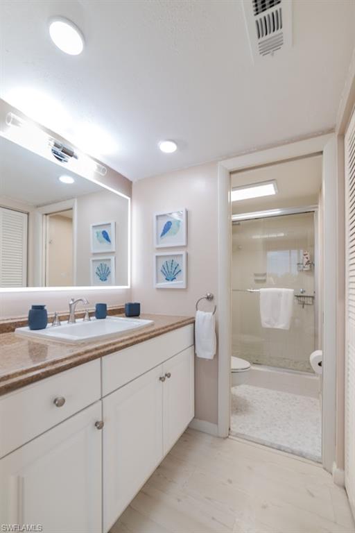 5 Bluebill Avenue, Unit 305 405 Naples, FL 34108 - Photo 11 of 30 a spacious bathroom with a granite countertop sink a toilet and a mirror