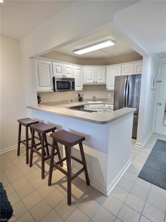 5 Bluebill Avenue, Unit 305 405 Naples, FL 34108 - Photo 12 of 30 a kitchen with kitchen island cabinets and refrigerator