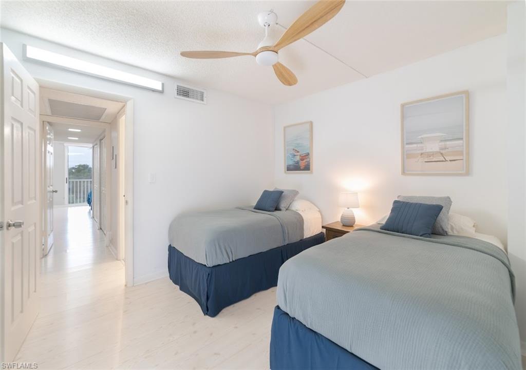 5 Bluebill Avenue, Unit 305 405 Naples, FL 34108 - Photo 15 of 30 a spacious bedroom with two beds and painting on the wall