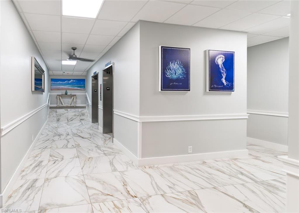 5 Bluebill Avenue, Unit 305 405 Naples, FL 34108 - Photo 20 of 30 a view of a hallway with wooden floor and furniture