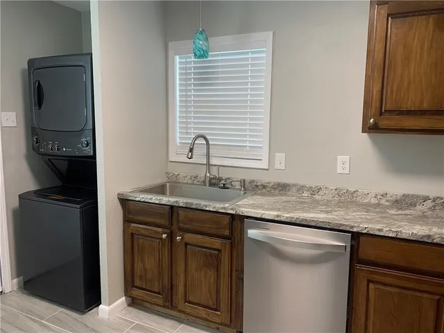 a kitchen with granite countertop a sink and a stove