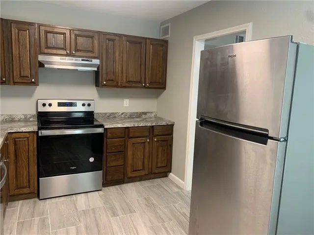 a kitchen with a refrigerator and a stove