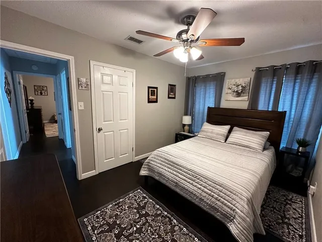 a bedroom with a large bed and a chandelier