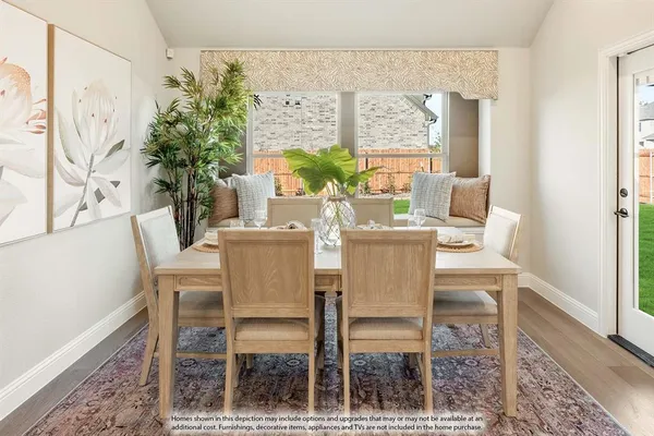 a dining room with furniture potted plants and wooden floor
