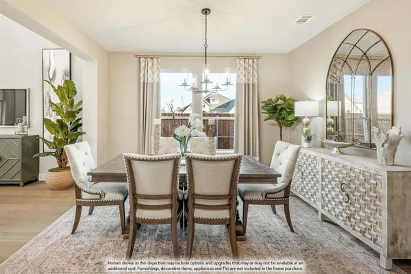 a dining room with furniture a potted plant and a chandelier