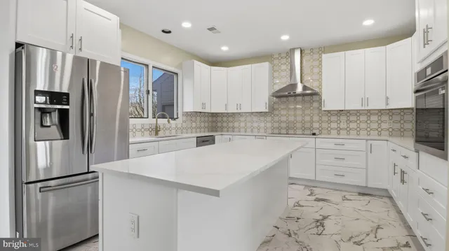 a large white kitchen with granite countertop a refrigerator and a stove
