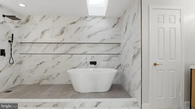 a bathroom with a white tub and shower