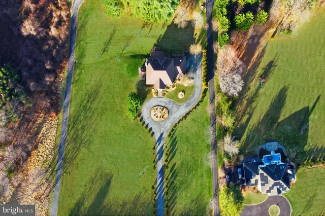 an aerial view of a house with garden space and swimming pool