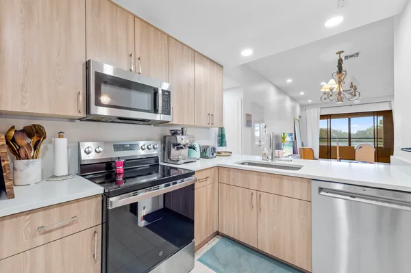 a kitchen with appliances a sink and cabinets