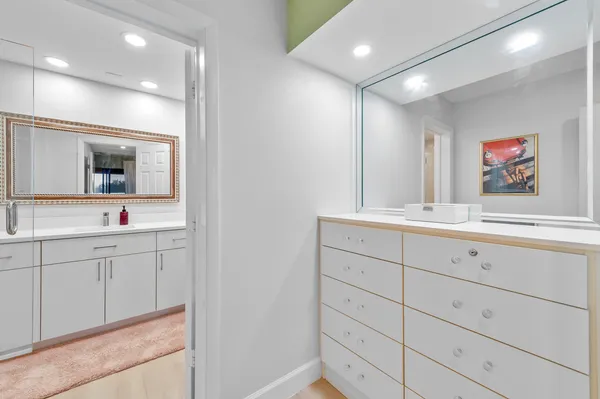a bathroom with a sink mirror and vanity