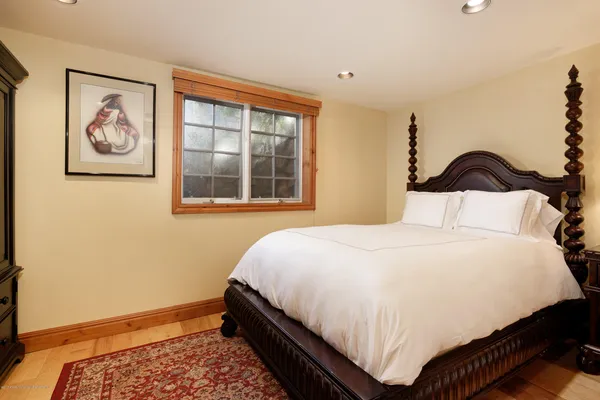 a bedroom with a bed and painting on the wall