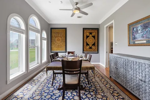 a dining room with furniture wooden floor a rug and a chandelier