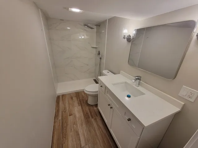 a bathroom with a sink mirror toilet and shower