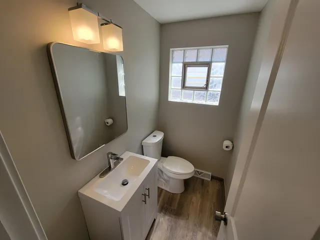 a bathroom with a toilet sink and mirror