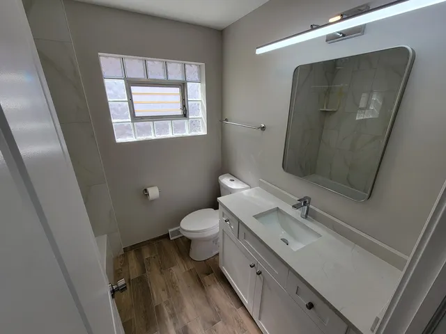 a bathroom with a toilet sink and mirror