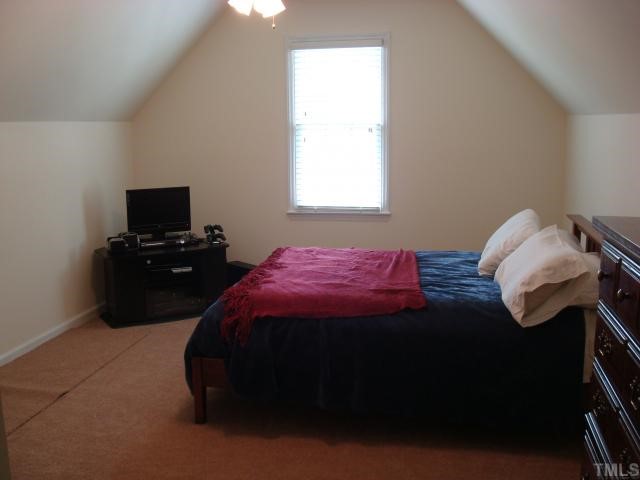 5017 Amberfield Way Raleigh, NC 27604 - Photo 8 of 10 a bedroom with a bed and a window