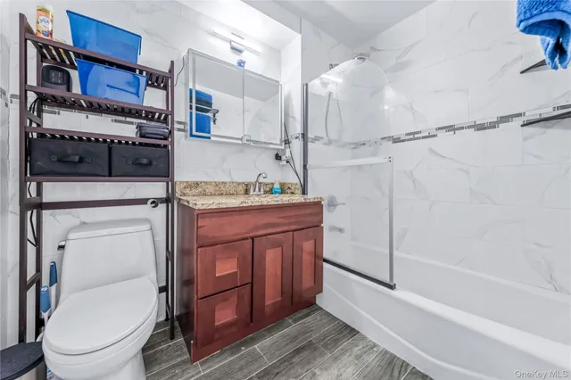 a bathroom with a granite countertop sink toilet and shower