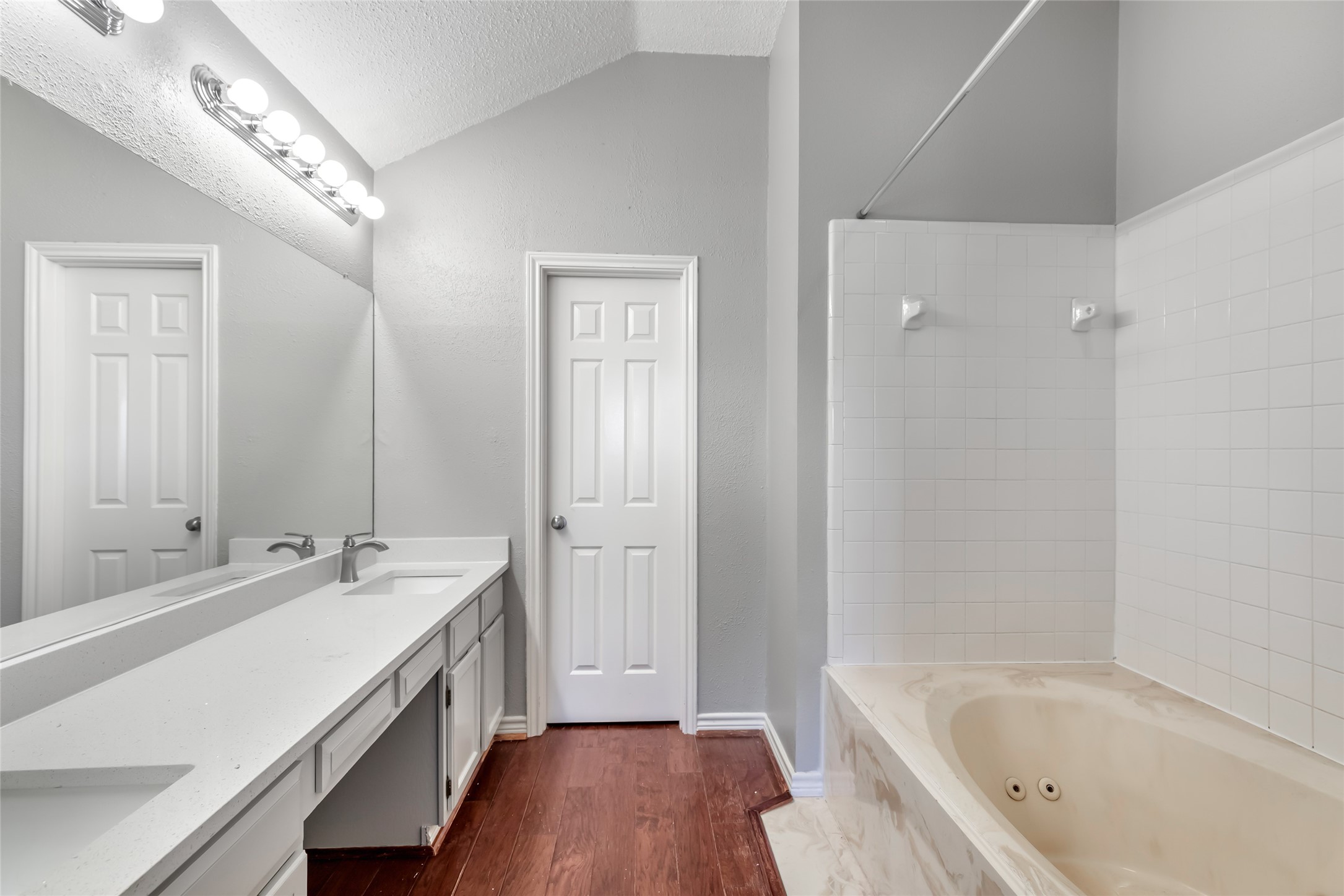 18910 Yaupon Trail Humble, TX 77346 - Photo 16 of 22 Master bathroom with quartz countertops, refreshed cabinetry, jetted tub, and walk-in closet