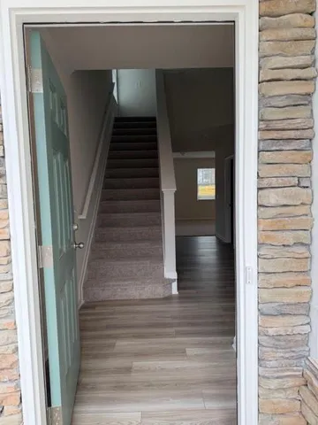 a view of entryway and hall with wooden floor
