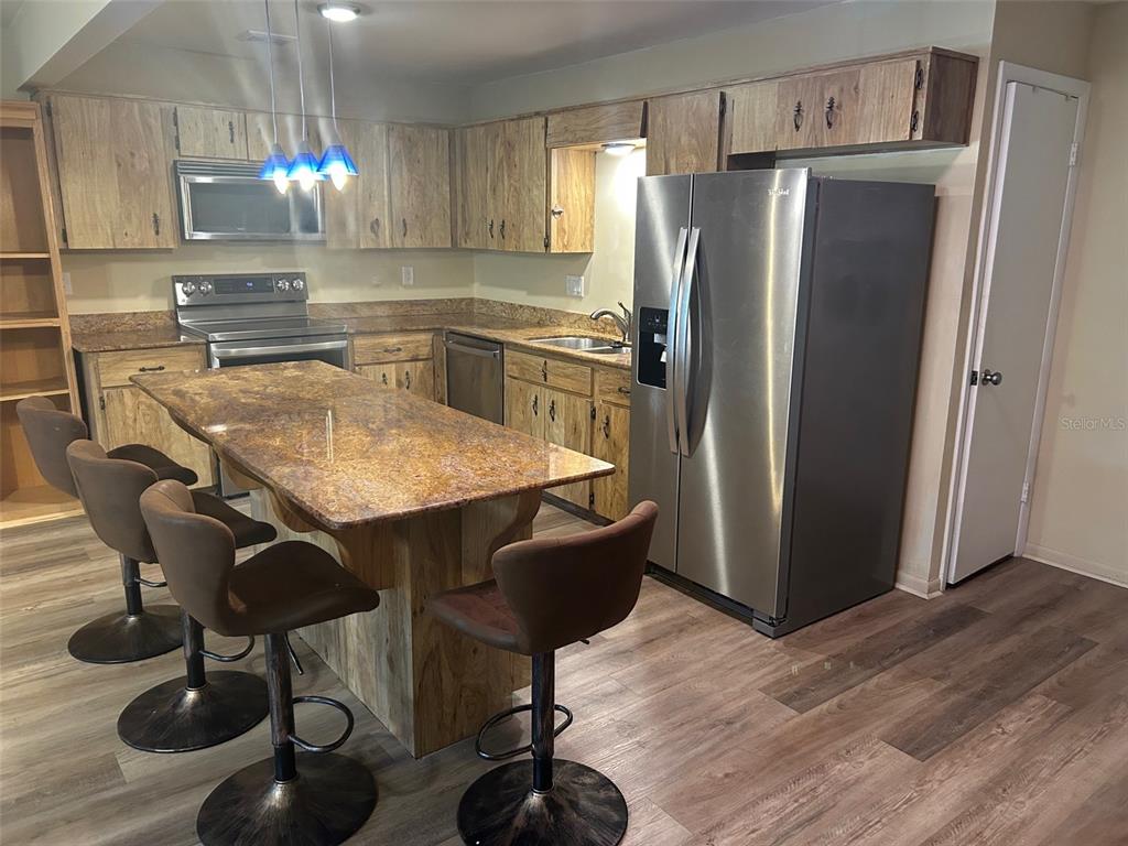 8655 Southwest 98th Street Road, Unit A Ocala, FL 34481 - Photo 14 of 24 Kitchen Island with granite counter top. Stainless steel appliances