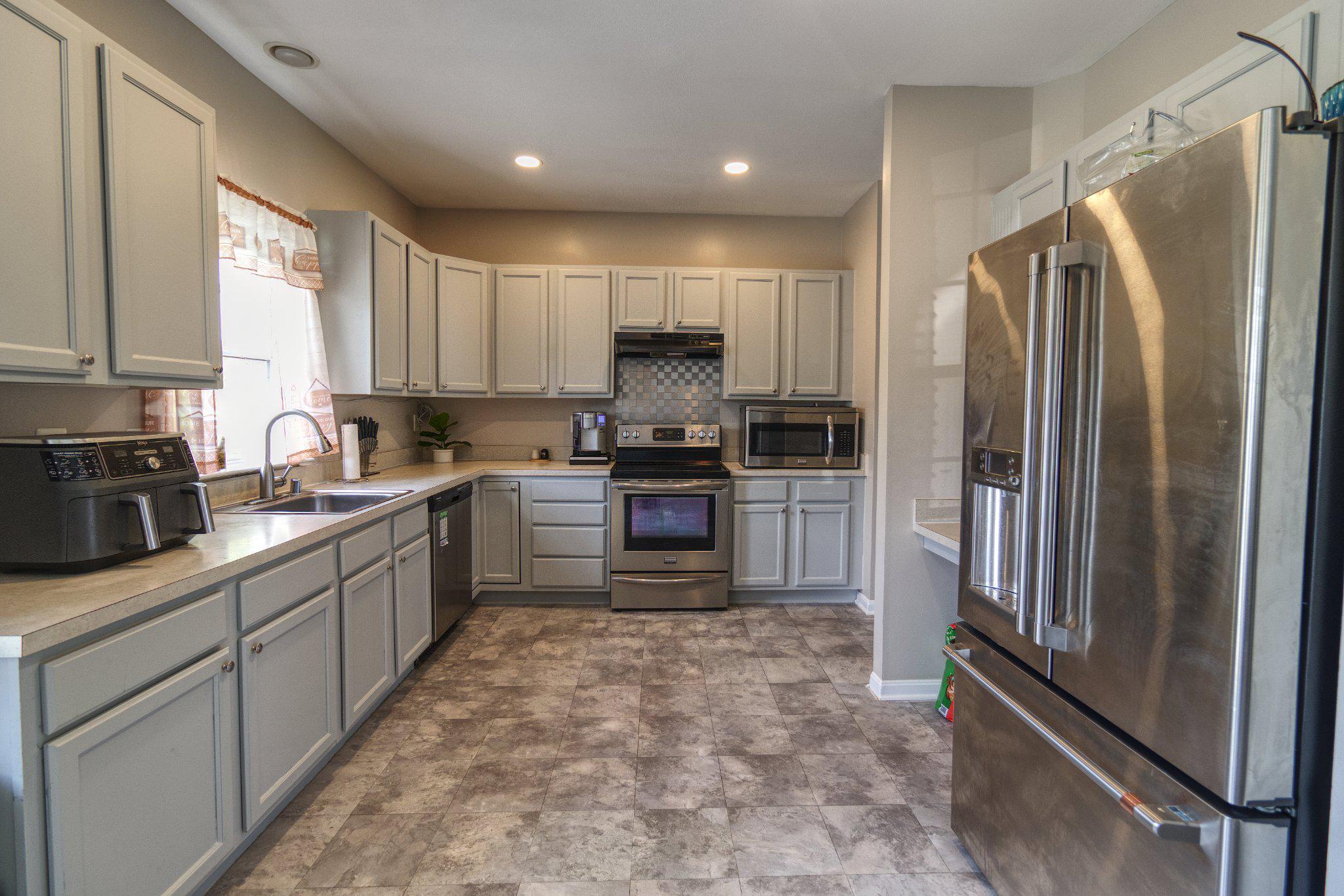 215 Seamaster Road Essex, MD 21221 - Photo 11 of 40 a kitchen with granite countertop a refrigerator and a sink