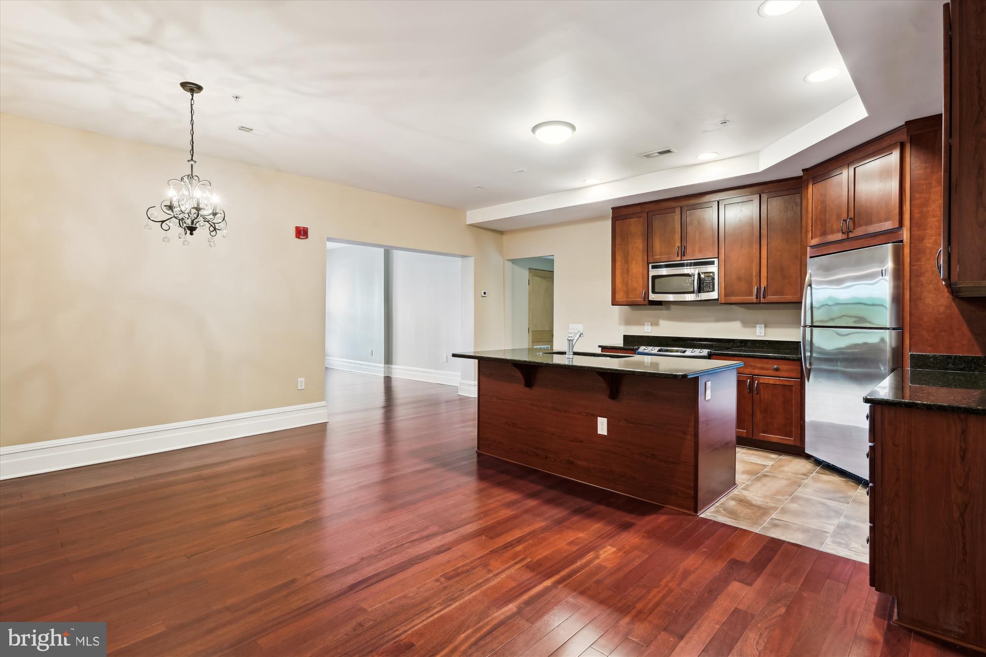 9610 Dewitt Drive, Unit PH410 Silver Spring, MD 20910 - Photo 4 of 64 a kitchen with stainless steel appliances granite countertop a refrigerator a sink dishwasher a stove and a dining table with wooden floor