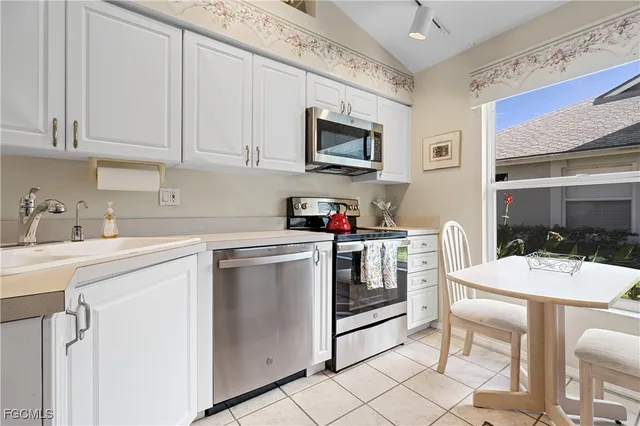 a kitchen with white cabinets and appliances