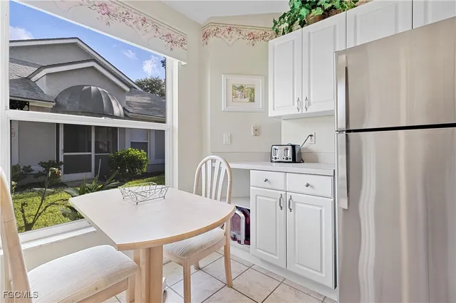 a kitchen with stainless steel appliances a refrigerator a sink a table and chairs