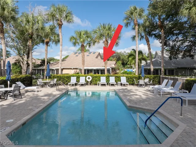 a view of a swimming pool with sitting area and furniture