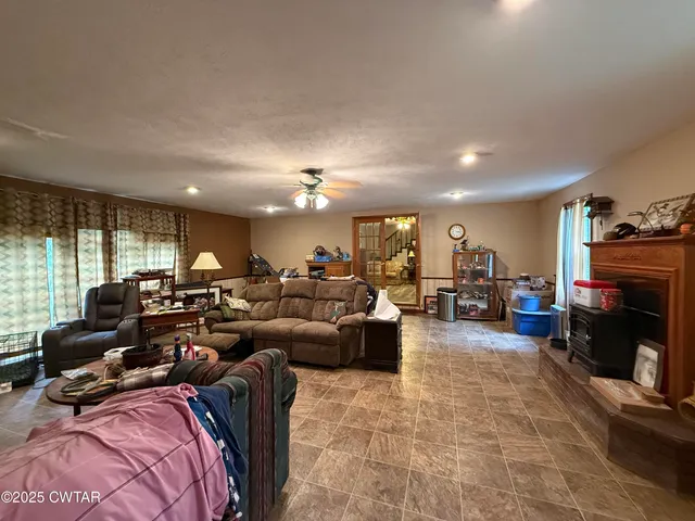 a living room with furniture a fireplace and a large window