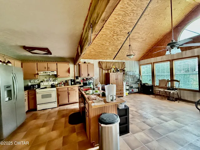 a kitchen with sink refrigerator and large window