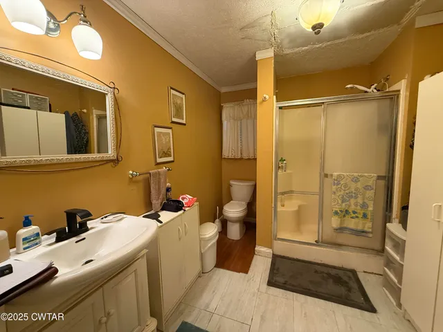 a bathroom with a sink a toilet and shower
