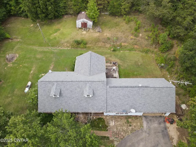 an aerial view of a house with a yard and lake view