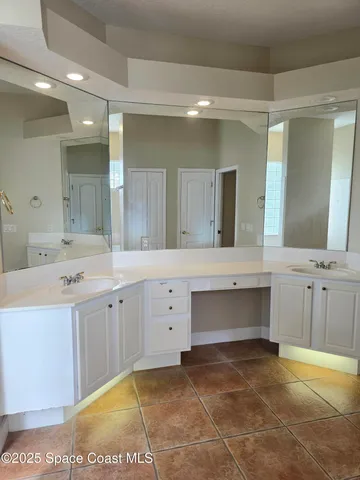 a spacious bathroom with a double vanity sink and a mirror