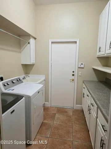 a utility room with sink dryer and washer